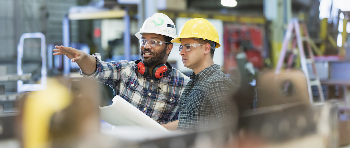 Two men conversing in an industrial setting
